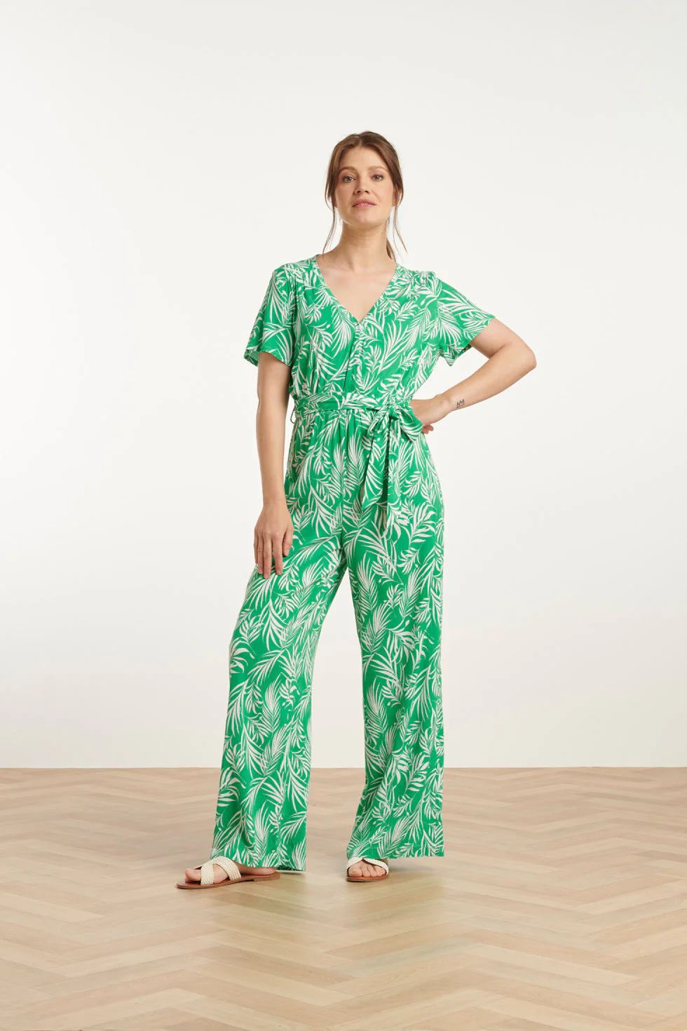 Smashed Lemon 25046 stretch jumpsuit met v-hals en bladprint in groen